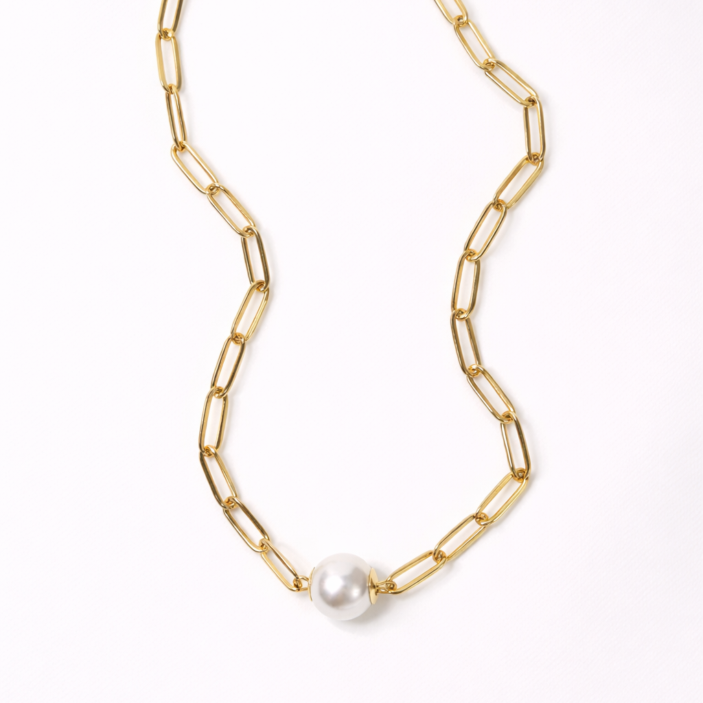 Gold chain necklace with a pearl pendant on a white background
